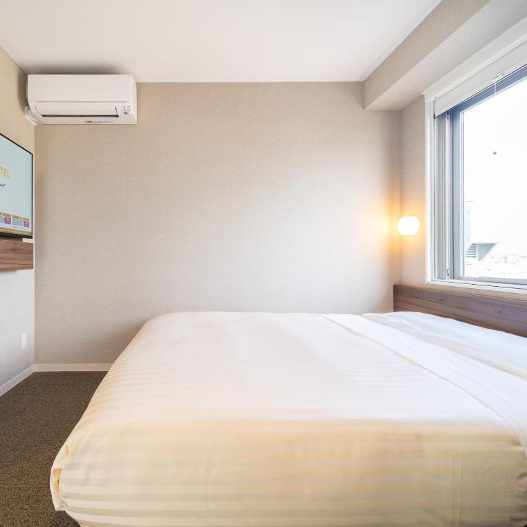 Postel nebo postele na pokoji v ubytování Super Hotel Joetsu Myoko-Eki Nishiguchi