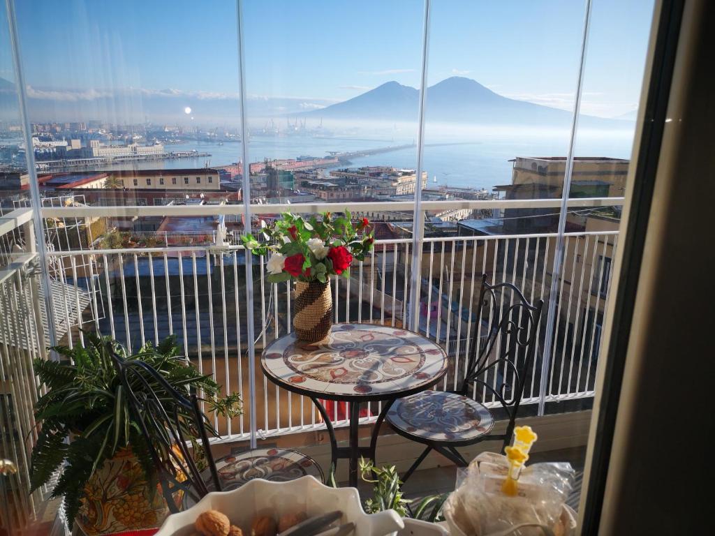 a balcony with a table with a vase of flowers at Suite Estasi in Naples
