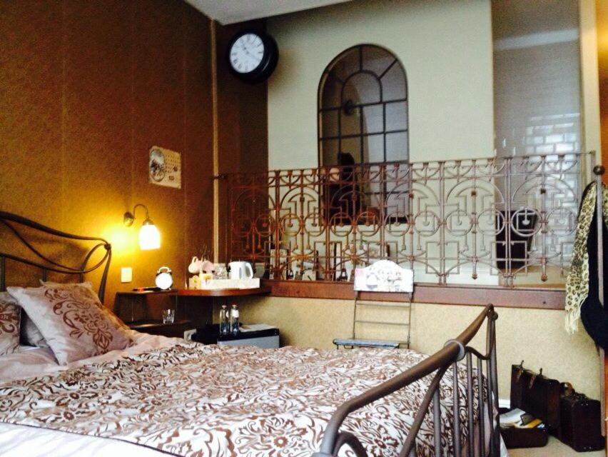 a bedroom with a bed and a clock on the wall at B&B Bon-Bon 'nuit' in Turnhout