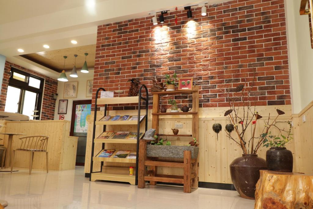 ein Zimmer mit einer Ziegelwand und einem Regal an einer Wand in der Unterkunft Le Ye B&B in Jinning