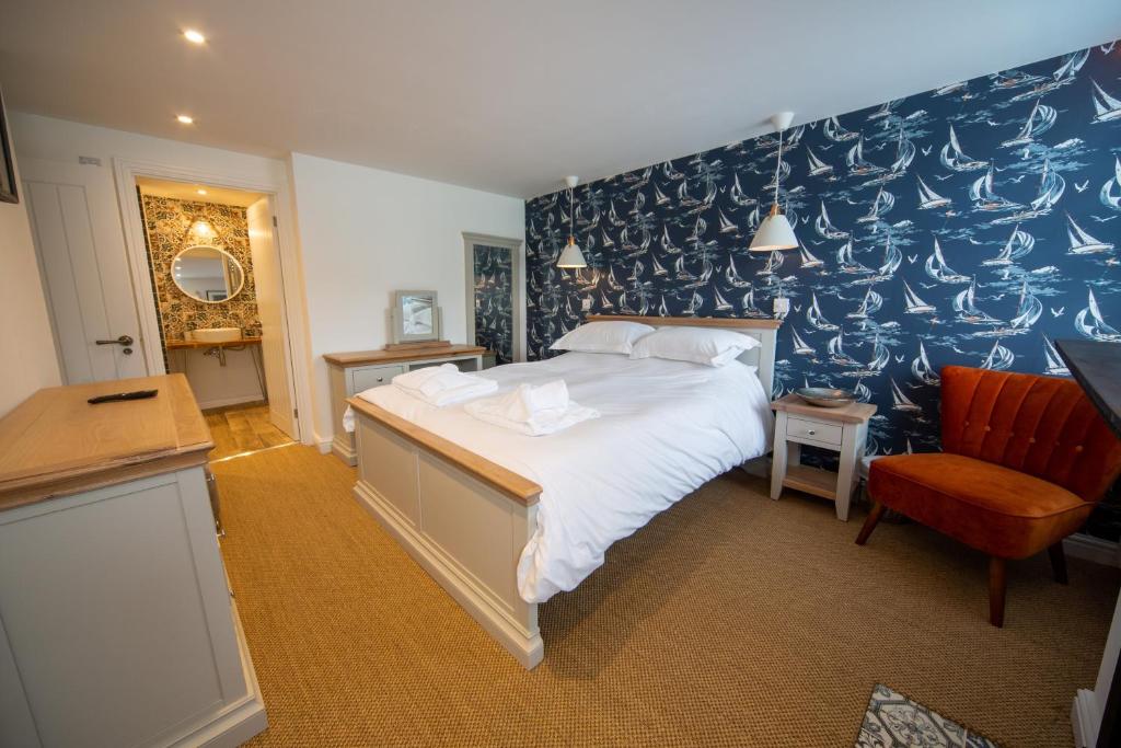 a bedroom with a large bed and a blue wall at Gelly Cott in Padstow