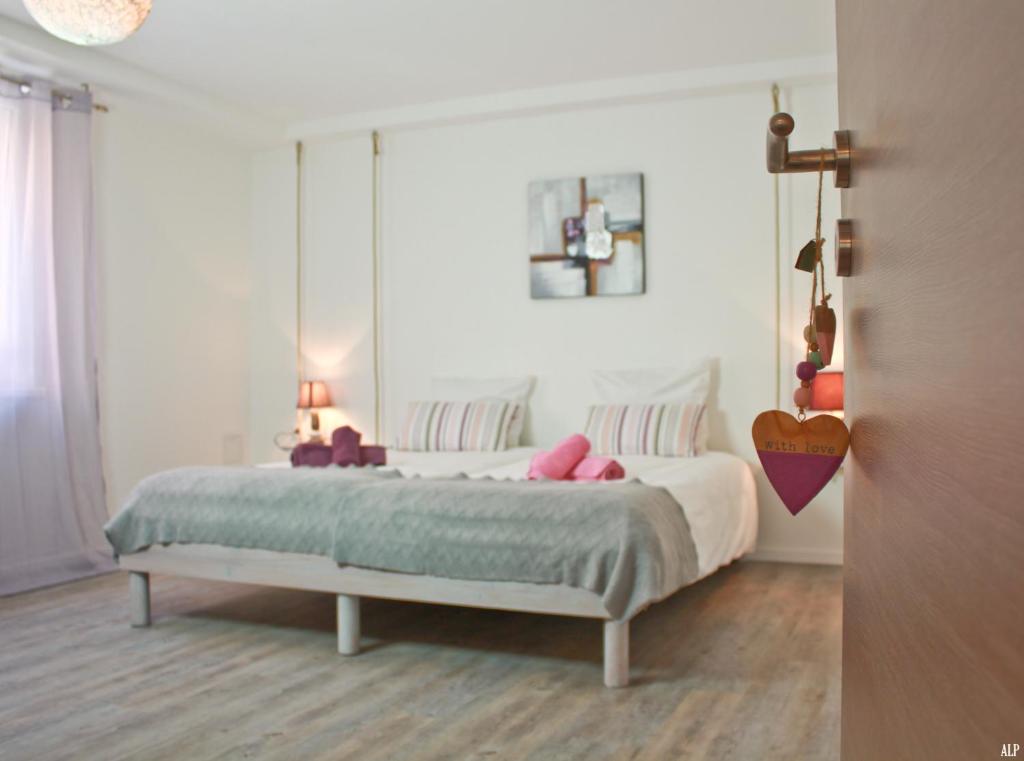sypialnia z dużym białym łóżkiem z różowymi poduszkami w obiekcie Les coeurs de Cachemire w mieście Breuschwickersheim