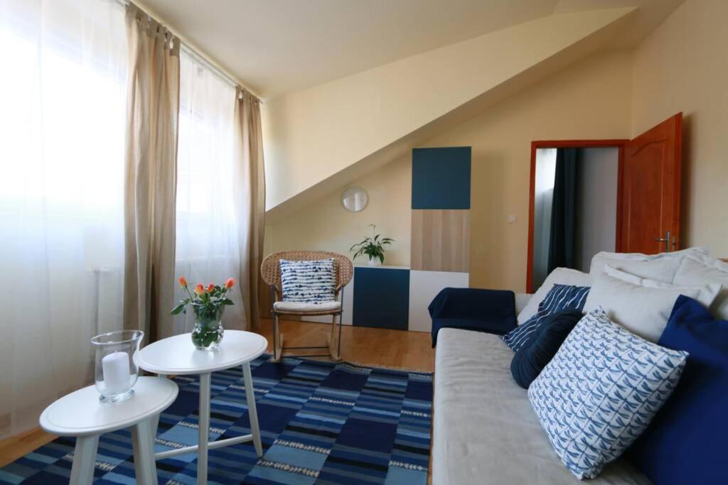 uma sala de estar com um sofá e duas mesas em Teubel apartman 2 em Székesfehérvár