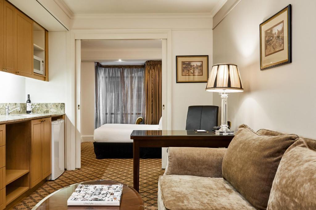 a hotel room with a couch and a bed at Stamford Plaza Melbourne in Melbourne