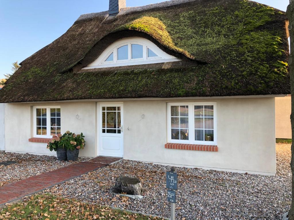 a white house with a thatched roof at Cora in Pruchten