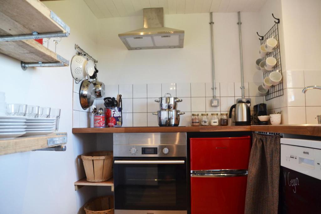 a kitchen with a red refrigerator and a stove at Milking Shed Cottage in Narberth