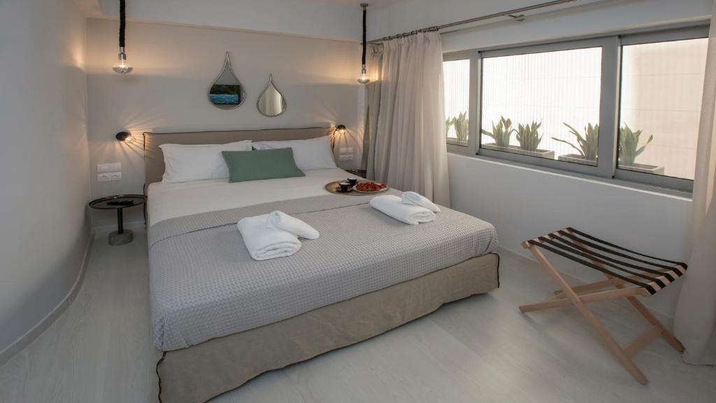 a bedroom with a bed with two towels on it at Ermou Stylish Suites by GHH in Athens