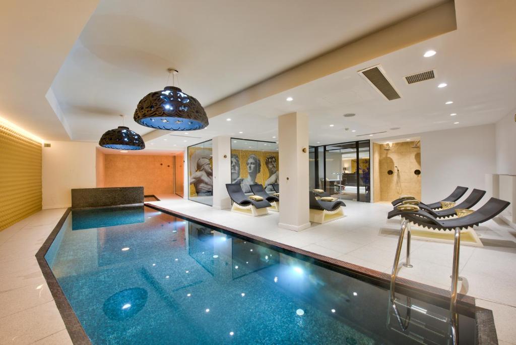 a swimming pool in a house with chairs at HOLM Boutique & SPA - IK Collection in St. Julianʼs