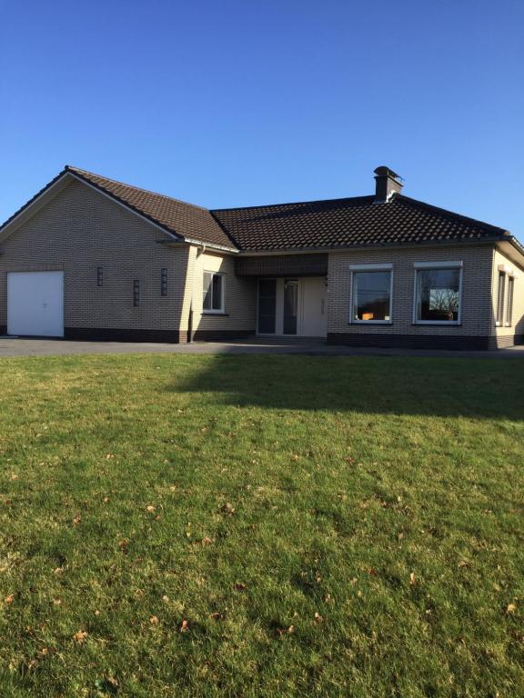 una casa con un grande prato di fronte di Vakantiehuis in Vlaamse Ardennen a Zottegem