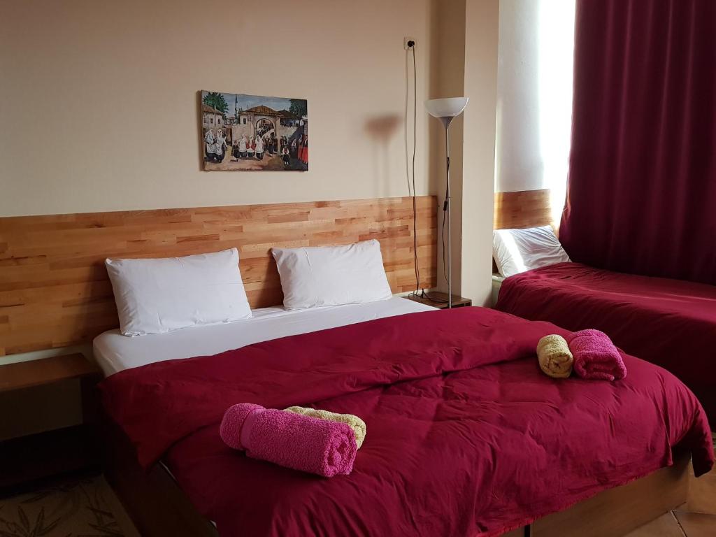 a bedroom with a bed with two stuffed animals on it at Hotel Kurtabeg in Shkodër