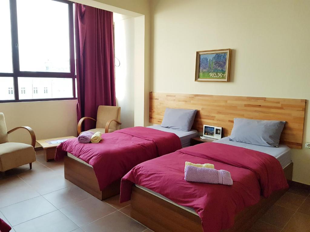 Una habitación de hotel con dos camas y una ventana. en Hotel Kurtabeg, en Shkodër