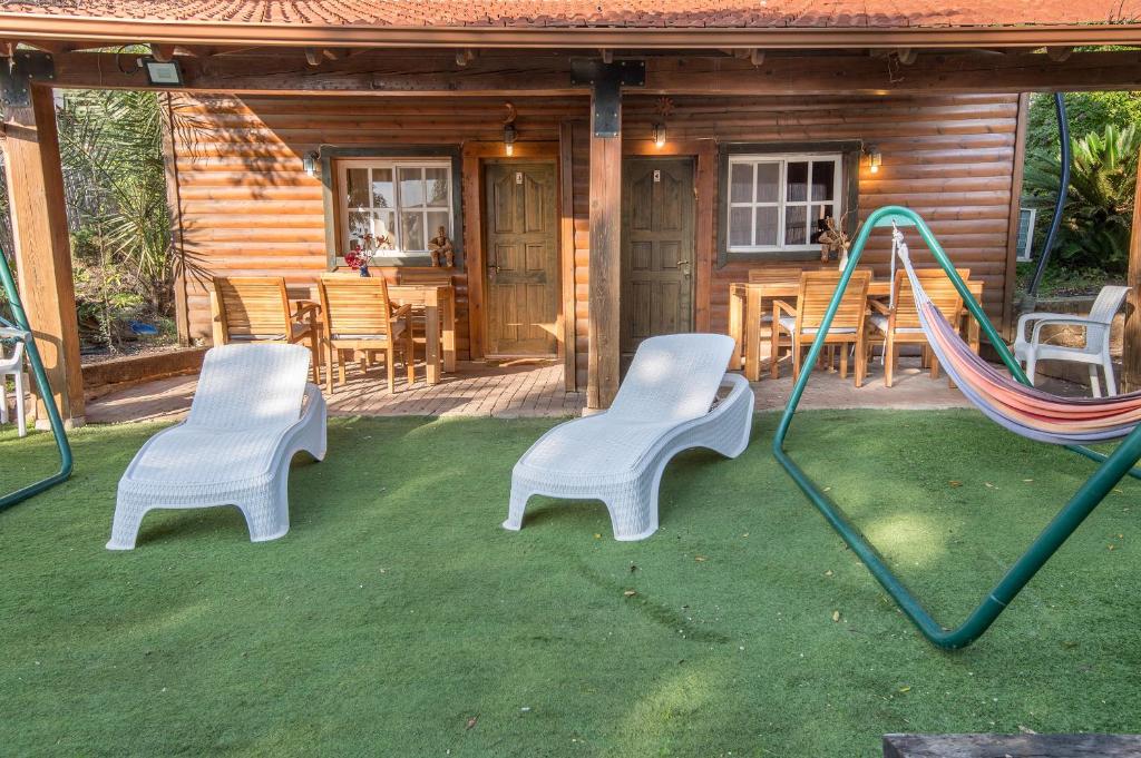 a playground with two chairs and a swing at Nof Kinneret Cabins in Had Nes
