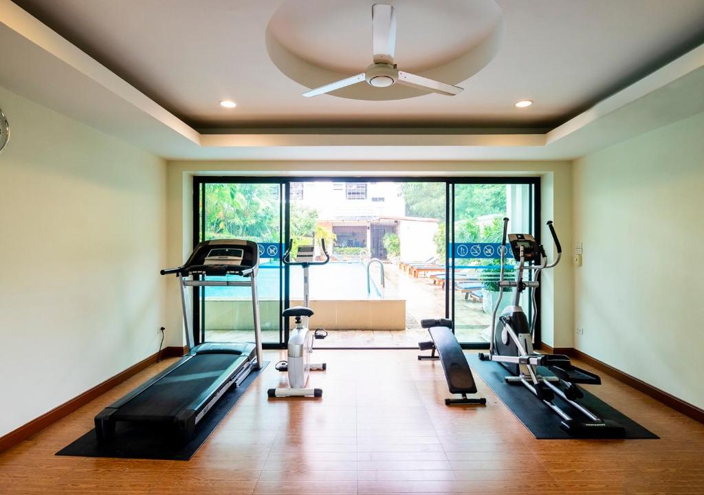 A compact fitness room overlooks the pool through wide glass doors.