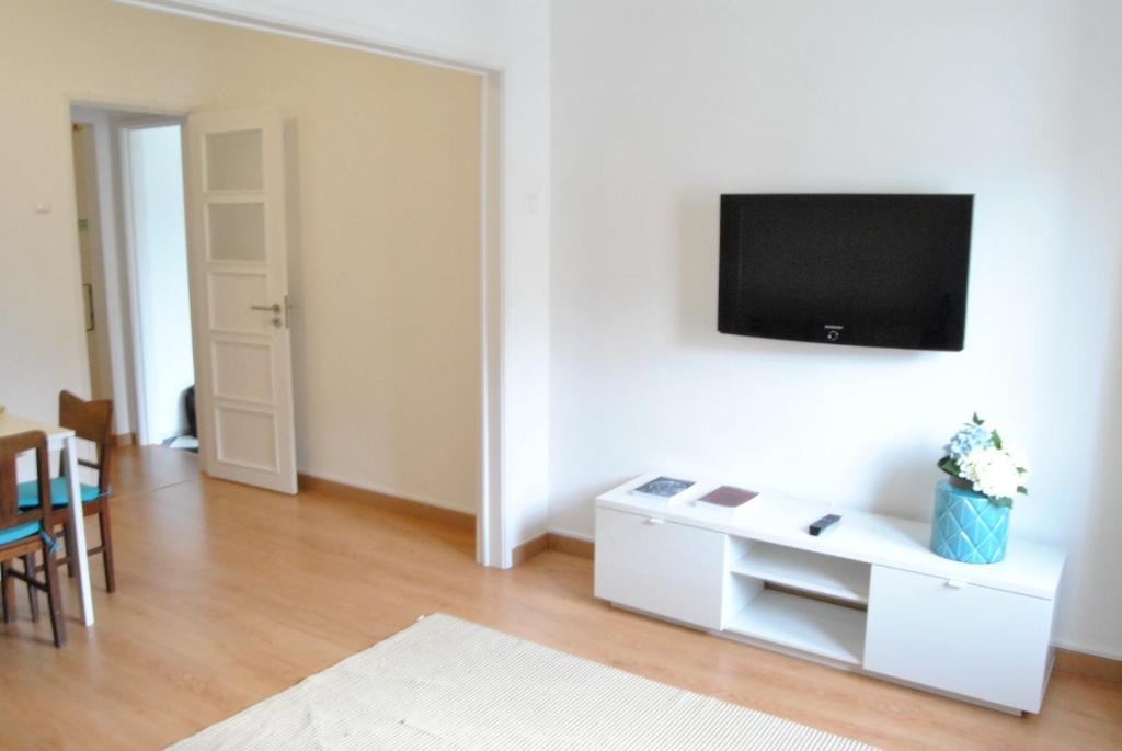 ein weißes Wohnzimmer mit einem TV an der Wand in der Unterkunft Dowtown Apartment - Expo20 in Lissabon