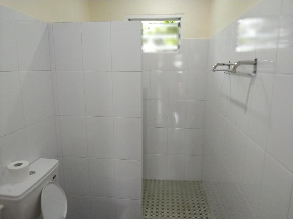 アピアにあるKuinis Guesthouseの白いバスルーム(トイレ、シャワー付)
