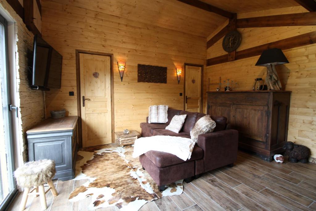 sala de estar con sofá en una sala de madera en Chalet des 2 moutons, en Le Taillan-Médoc