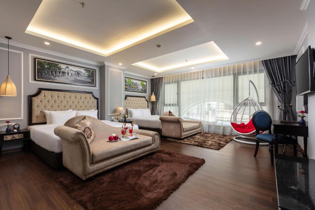 a bedroom with a bed and a couch and a chair at Babylon Premium Hotel & Spa in Hanoi