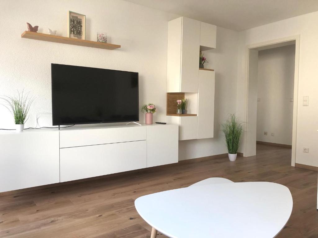 a living room with a flat screen tv on a white cabinet at Zollernalb-Apartment G6 in Albstadt