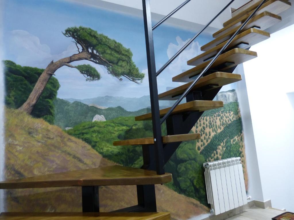 un mural en la pared de una escalera con una escalera en casa CAZORLA C DEL VALLE, en Cazorla