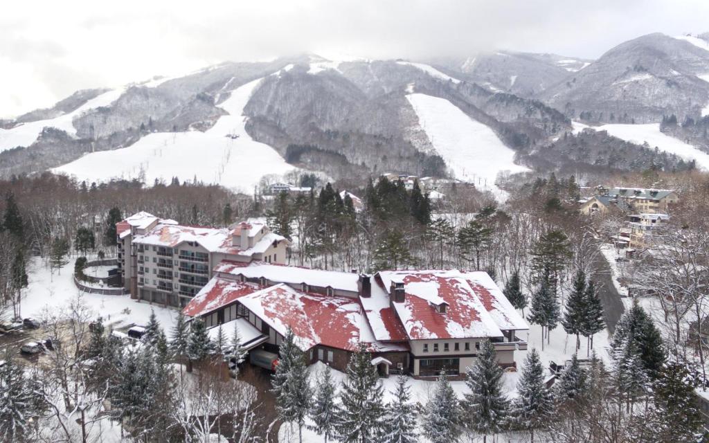 um resort nas montanhas cobertas de neve em Hakuba Tokyu Hotel em Hakuba