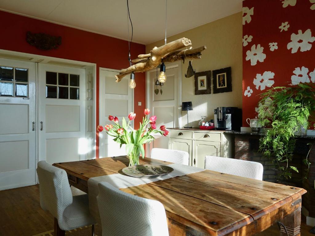 a kitchen with a wooden table with a vase of flowers at B&B de Pastory in Warns