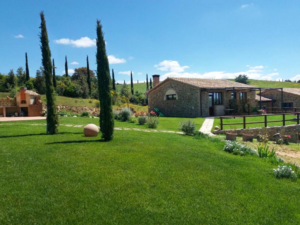 un patio con árboles y una casa al fondo en Agriturismo La Fonte, en Poggio Cavallo
