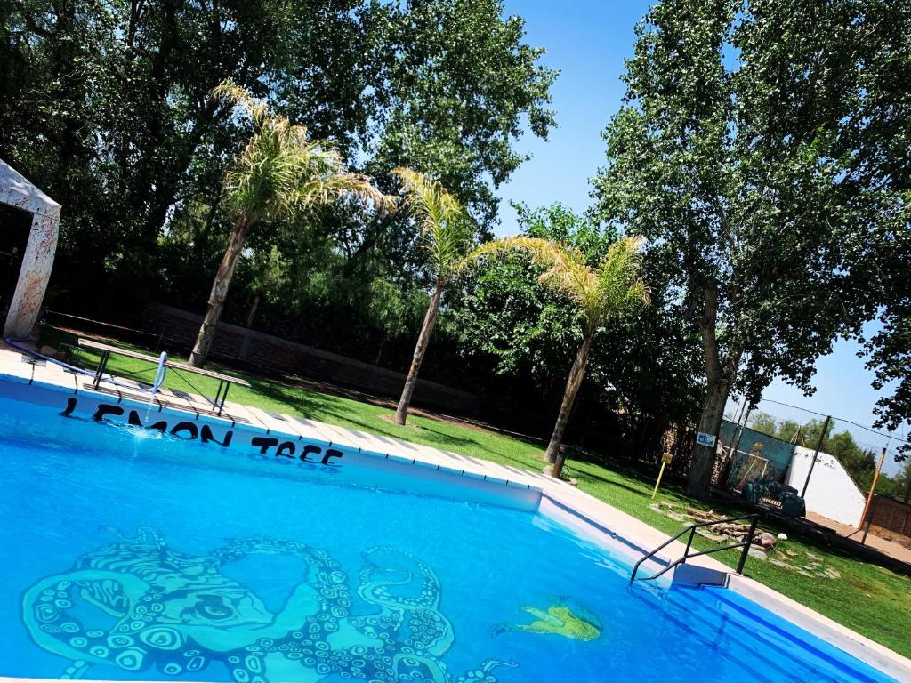 a large blue swimming pool with a sign on it at Lemon Tree Hostel in Vistalba