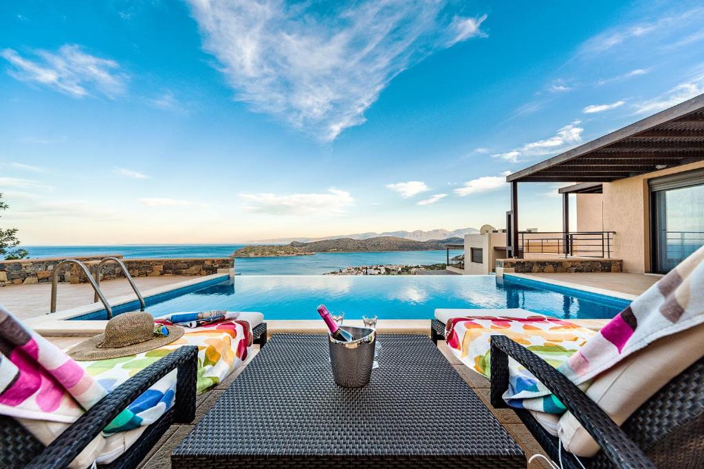 a villa with a swimming pool with a view of the ocean at villa OLGA - Sea and mountains view Private pool in Elounda