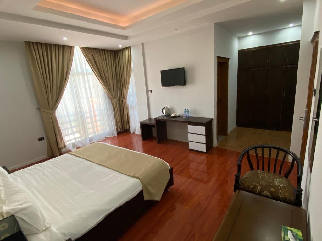 Un dormitorio con una cama, un escritorio y un televisor. en Afro legacy hotel, en Addis Ababa