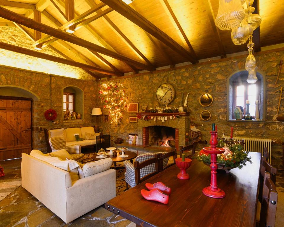 a living room with a couch and a fireplace at Guesthouse Karahalios in Polydrossos