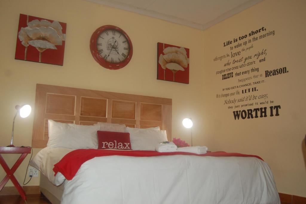 a bedroom with a bed and a clock on the wall at Jozini Lebombo Lodge in Jozini