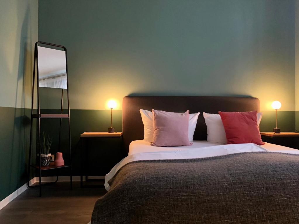 una camera da letto con letto, cuscini e specchio di Pension Mariposa a Weimar