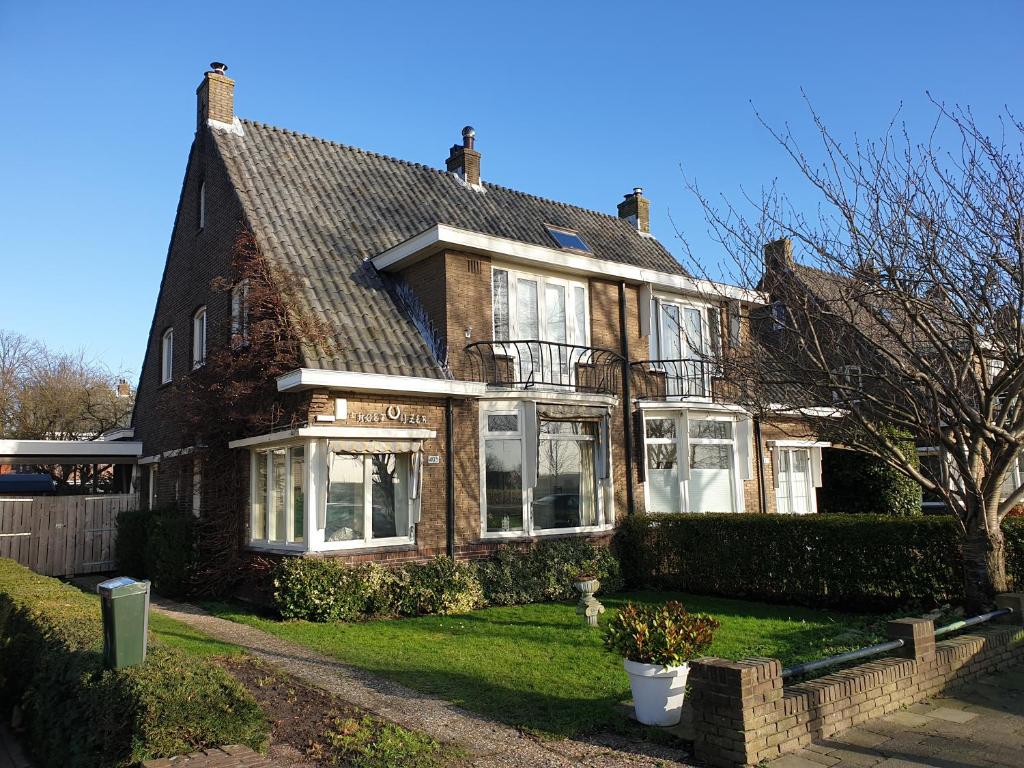 a brown house with white windows and a yard at Bed & Bye Schiphol in Badhoevedorp