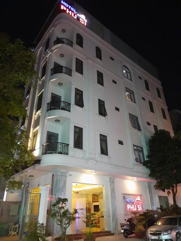 Un bâtiment blanc avec un panneau en haut dans l'établissement Hotel Phú Sĩ, à Hô-Chi-Minh-Ville