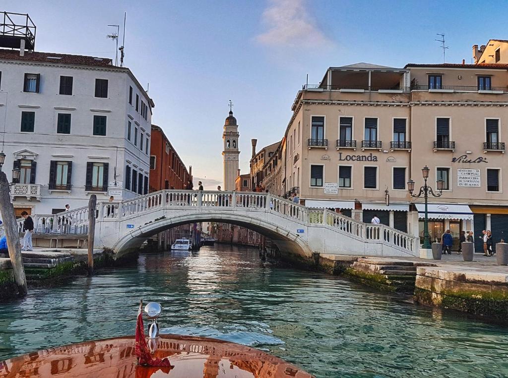a bridge over a river in a city with buildings at Locanda Vivaldi in Venice