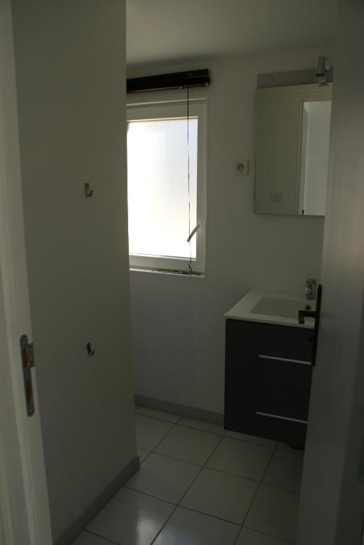 a white bathroom with a sink and a window at Paranthese à Marennes in Marennes