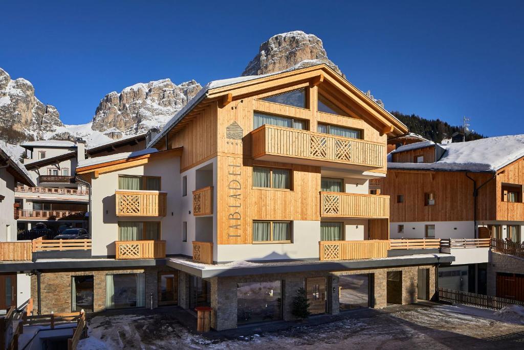 a building with a mountain in the background at Hotel Tabladel in Colfosco