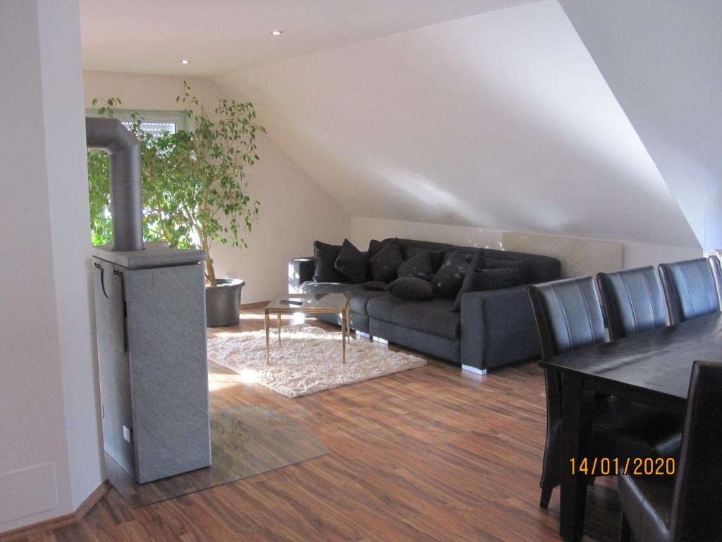 a living room with a black couch and a fireplace at Ferien- bzw. Zeitwohnen Burglengenfeld in Burglengenfeld