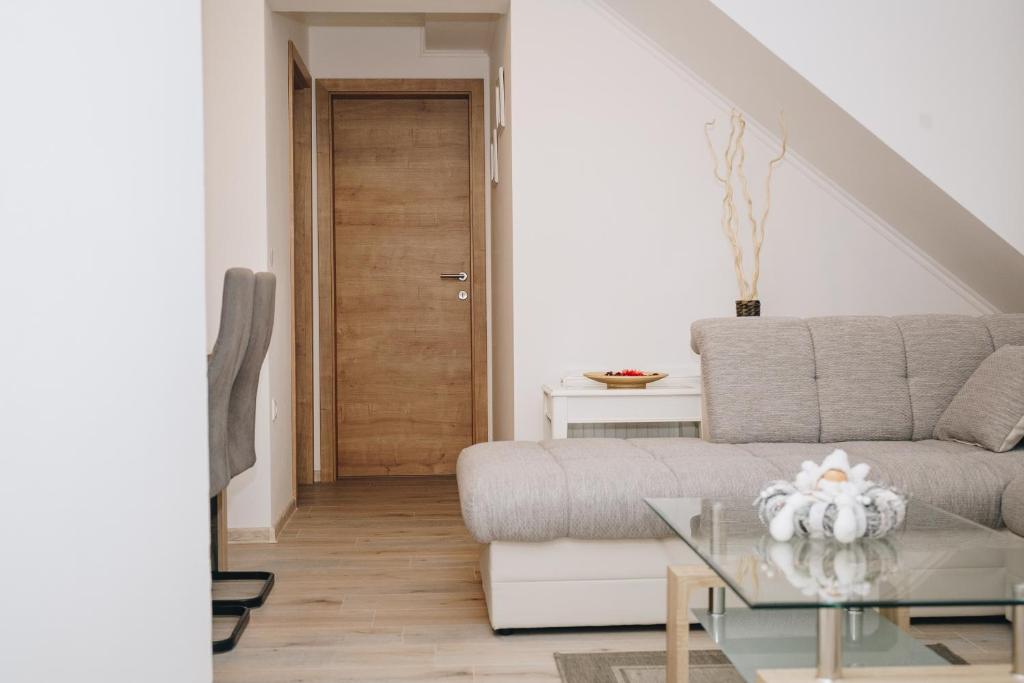 a living room with a couch and a glass table at Grom Ribno Apartments in Bled