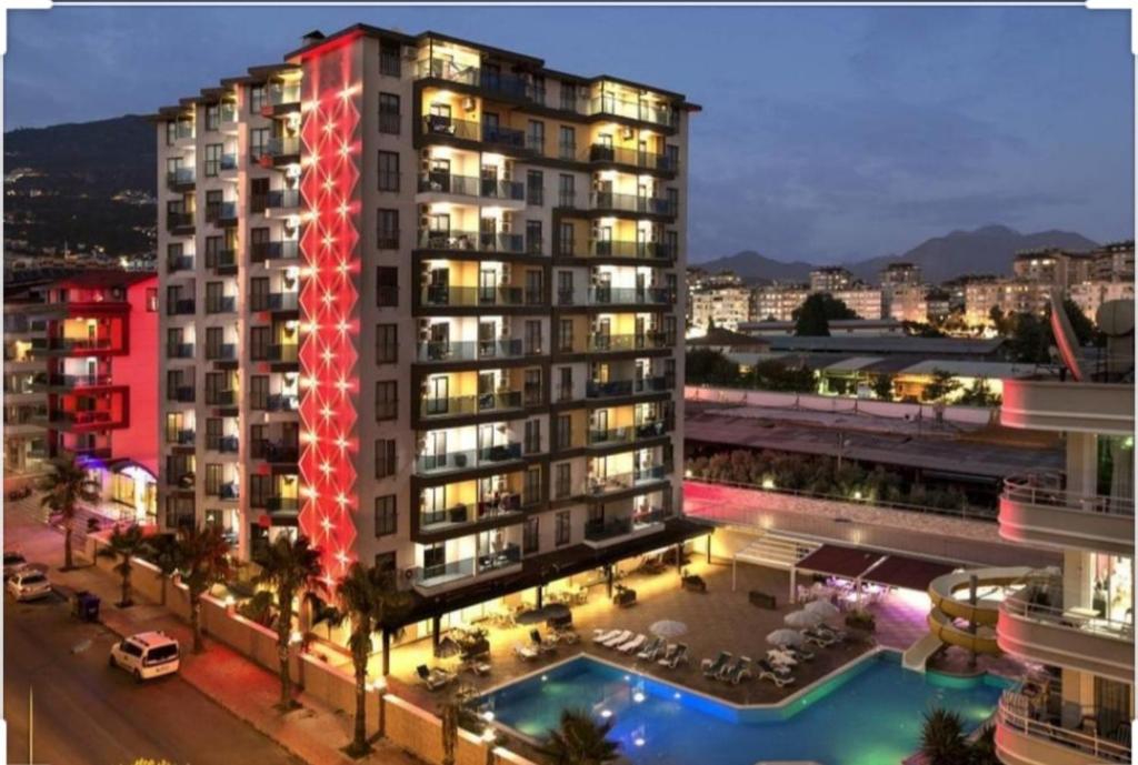 a large building with a pool in front of it at Granada City Alanya Luxury Appartment 800м от пляжа Клеопатра in Alanya