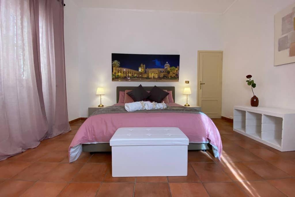 um quarto com uma cama grande e um cobertor rosa em Casa Vacanze Antico Cassaro em Palermo