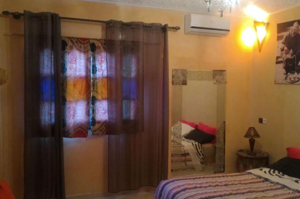 - une chambre avec un lit et un grand miroir dans l'établissement Maison Zaitouna, à Marrakech