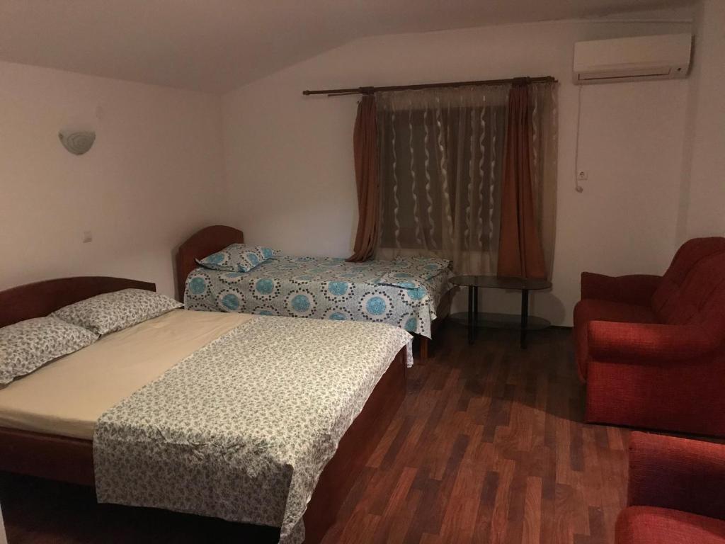 ママイア・ノルドにあるVilla Rosaのベッドルーム1室(ベッド2台、赤い椅子付)