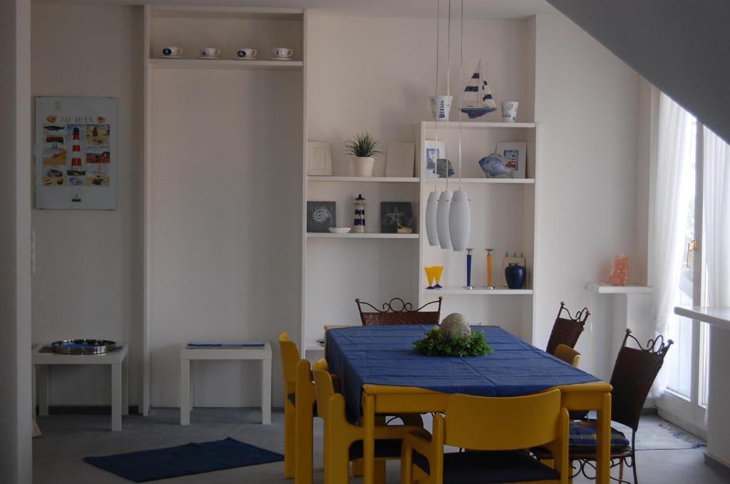 ein Esszimmer mit einem blauen Tisch und gelben Stühlen in der Unterkunft Komfortferienwohnung in ruhiger Lage mit 128qm in Grömitz in Grömitz