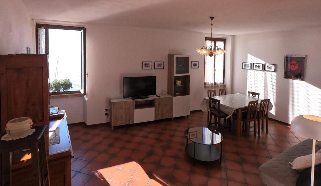 un soggiorno con TV e una sala da pranzo di Appartamento Panorama a Toscolano Maderno