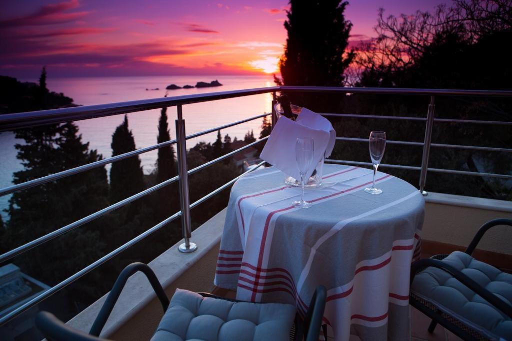 a table on a balcony with a wine glass at Apartment Vista 1 in Dubrovnik