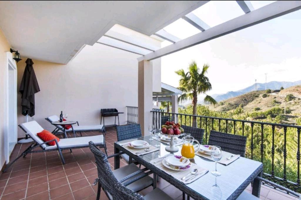 a dining room with a table and chairs on a balcony at INTMA LUXURY HoME in Alhaurín el Grande
