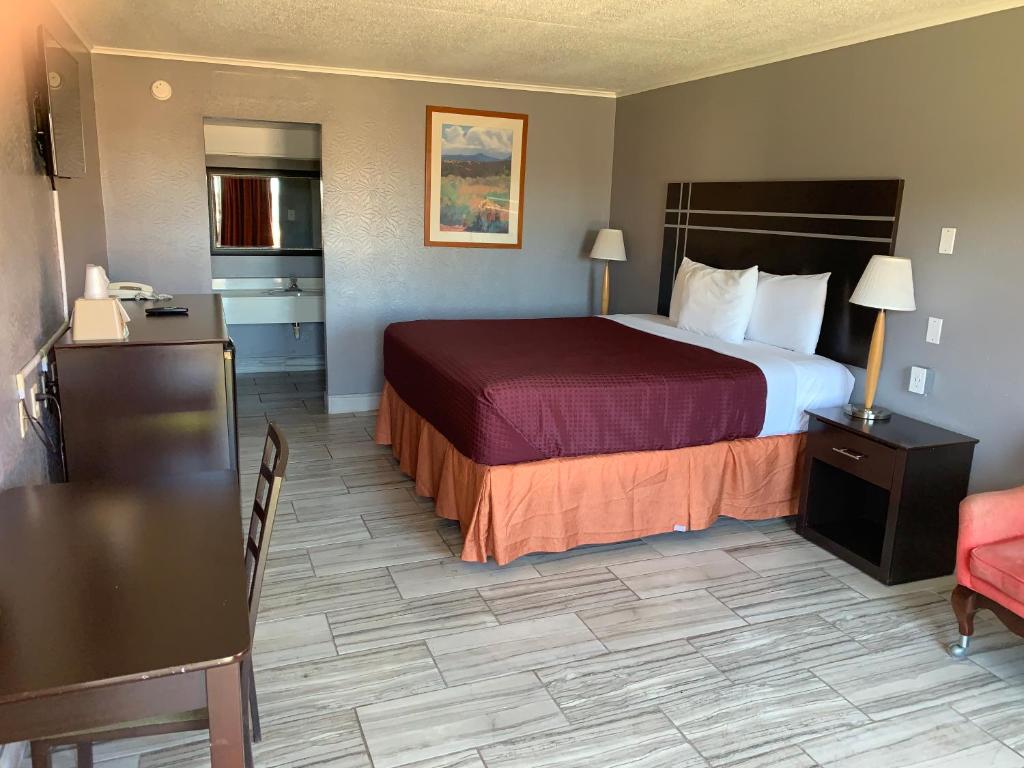 a hotel room with a large bed and a kitchen at Executive Inn in Beeville