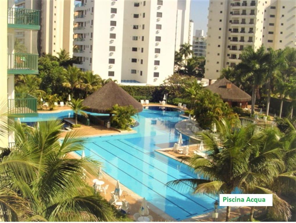 una vista aérea de la piscina del complejo con palmeras en Riviera São Lourenço Acqua en Bertioga