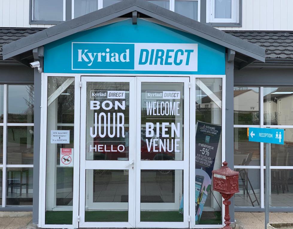 un magasin avec des panneaux à l'avant dans l'établissement Kyriad Direct Val de Reuil, à Val de Reuil